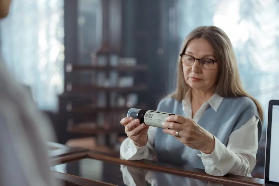 Woman reading the label on a bottled wellness product